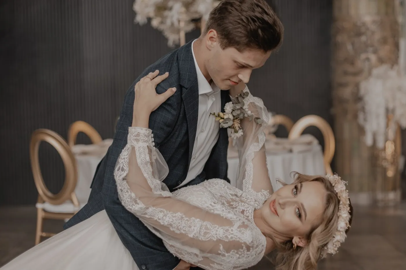 Pan młody przechyla roześmianą pannę młodą w tańcu